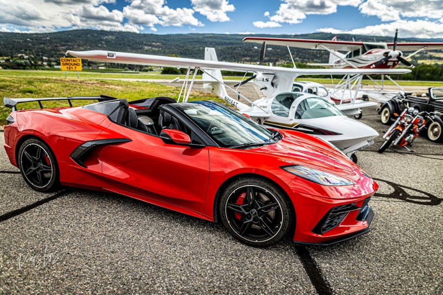 <who>Photo credit: Deans Lens</who>A C8 Corvette with a Super Petrel and float plane in the background.