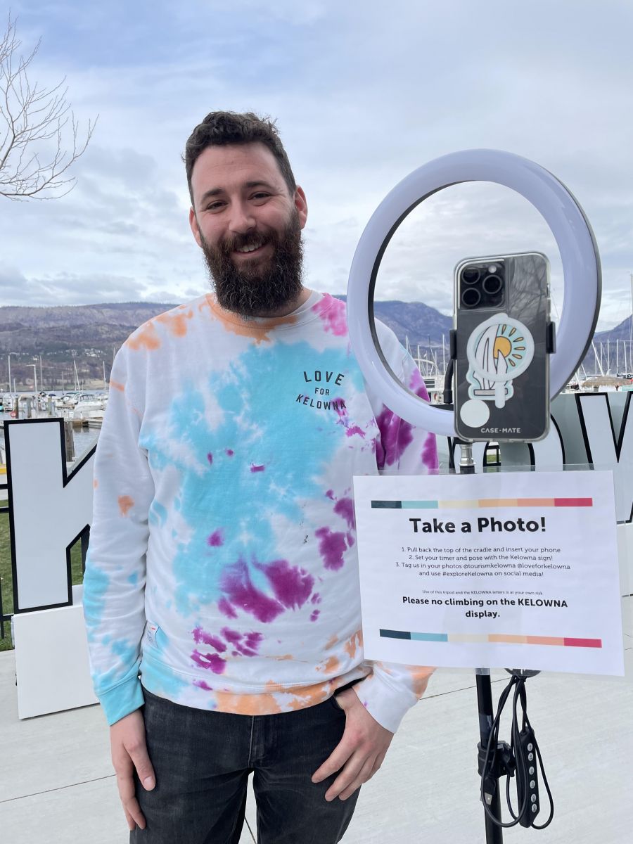 <who>Photo credit: Steve MacNaull/KelownaNow</who>Tourism Kelowna's Chris Lewis with the light-ring tripod people can use to get photos of themselves with the new Kelowna sign.