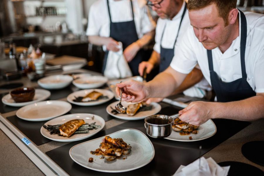 <who>Photo credit: Nic Collar Films</who>Chef Neil Taylor finishes plates at Home Block restaurant at CedarCreek Estate Winery.